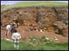 Mr Ahmet Ko&ccedil;ak, Aydincik Belediye Baskan, looks on while Mevl&uuml;t &Uuml;y&uuml;mez and Geoffrey Summers examine the stratigraphy of the uppermost burnt level.